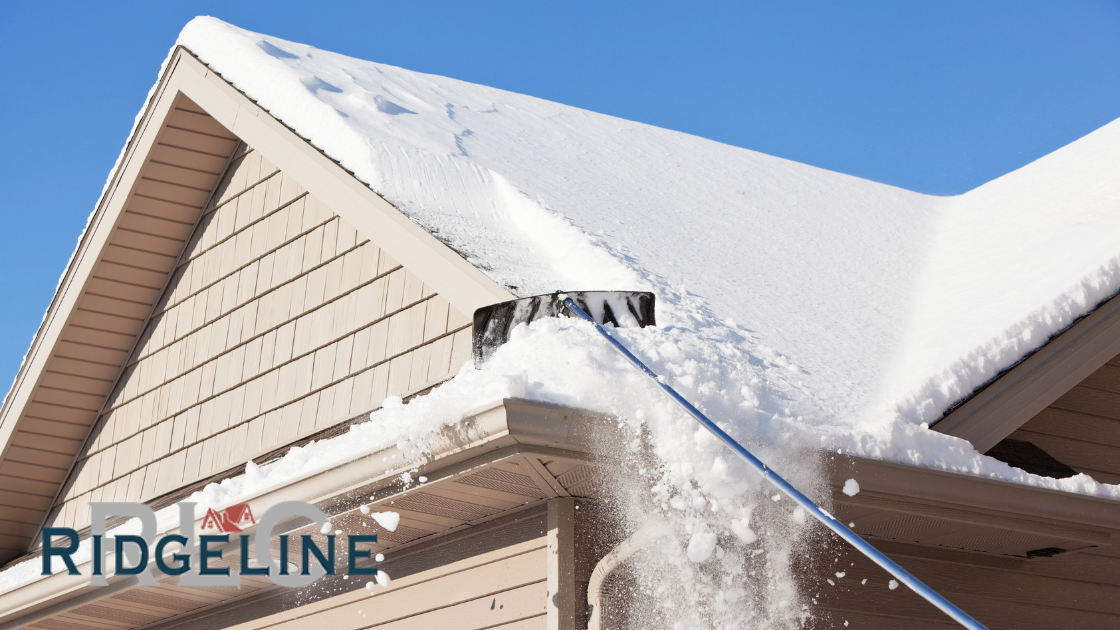 Snow being raked off a house roof with a roof rake