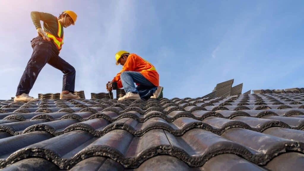 workers setting tiles on a roof