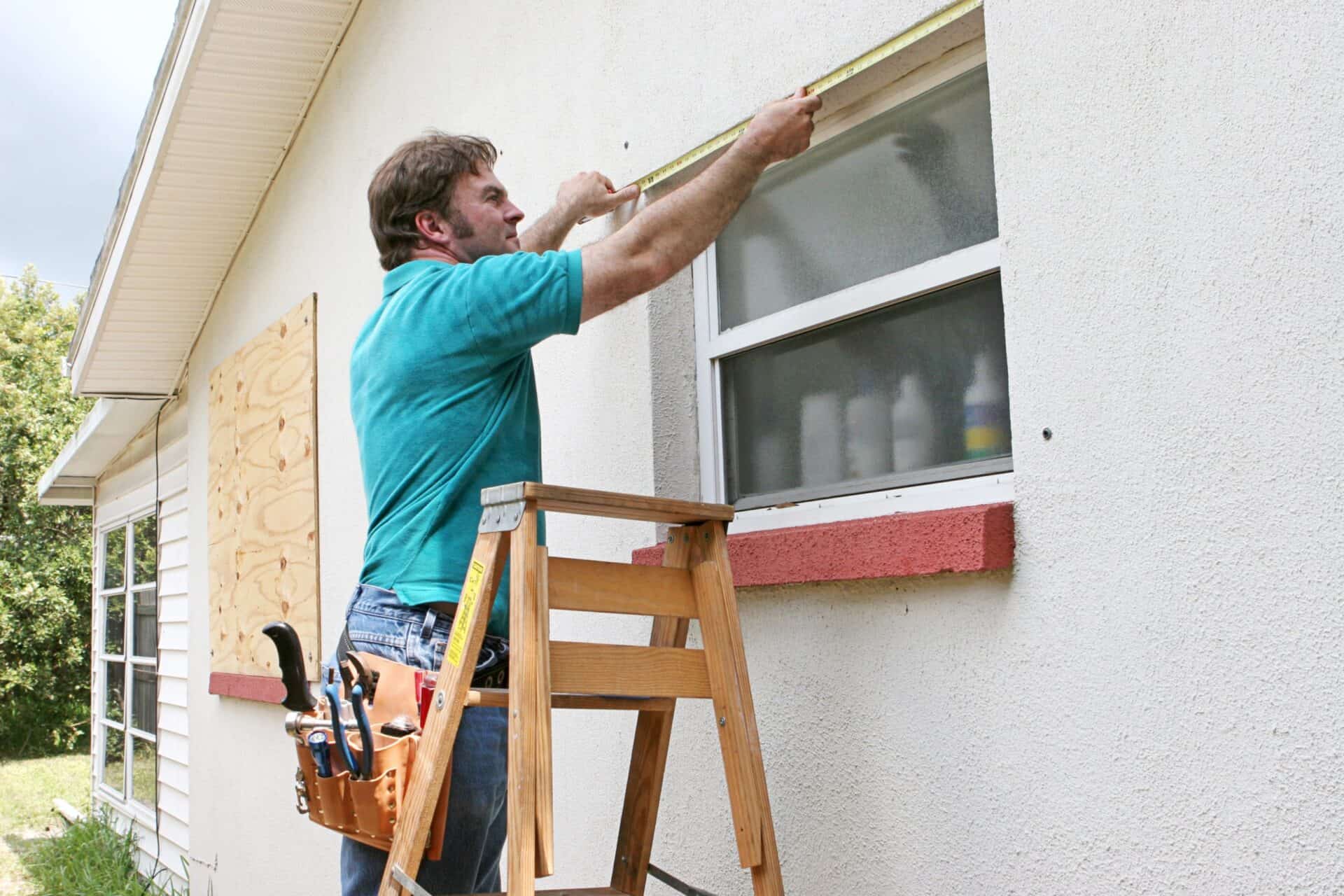 a man measuring a window